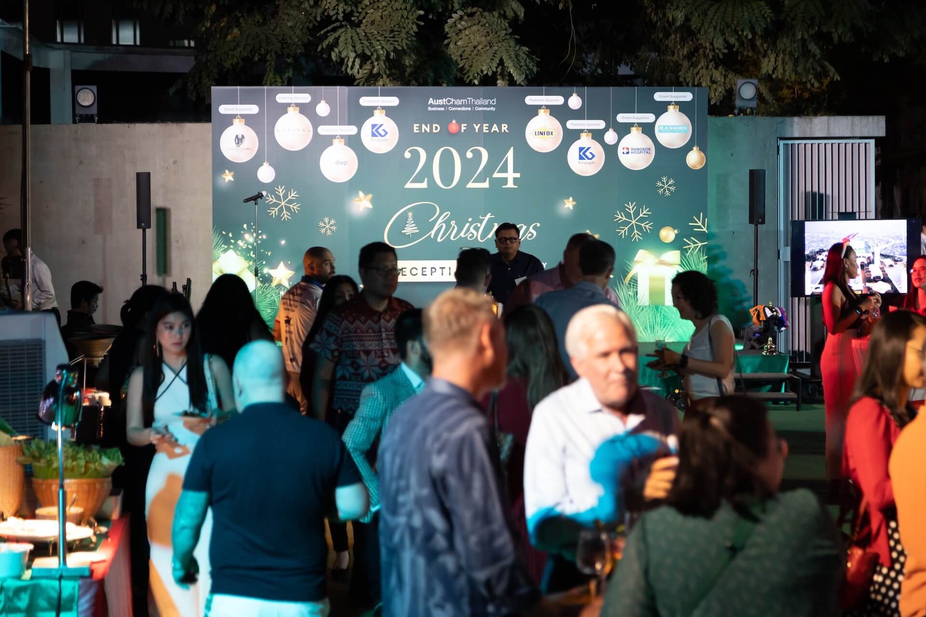 A crowded end of year party under festive lighting
