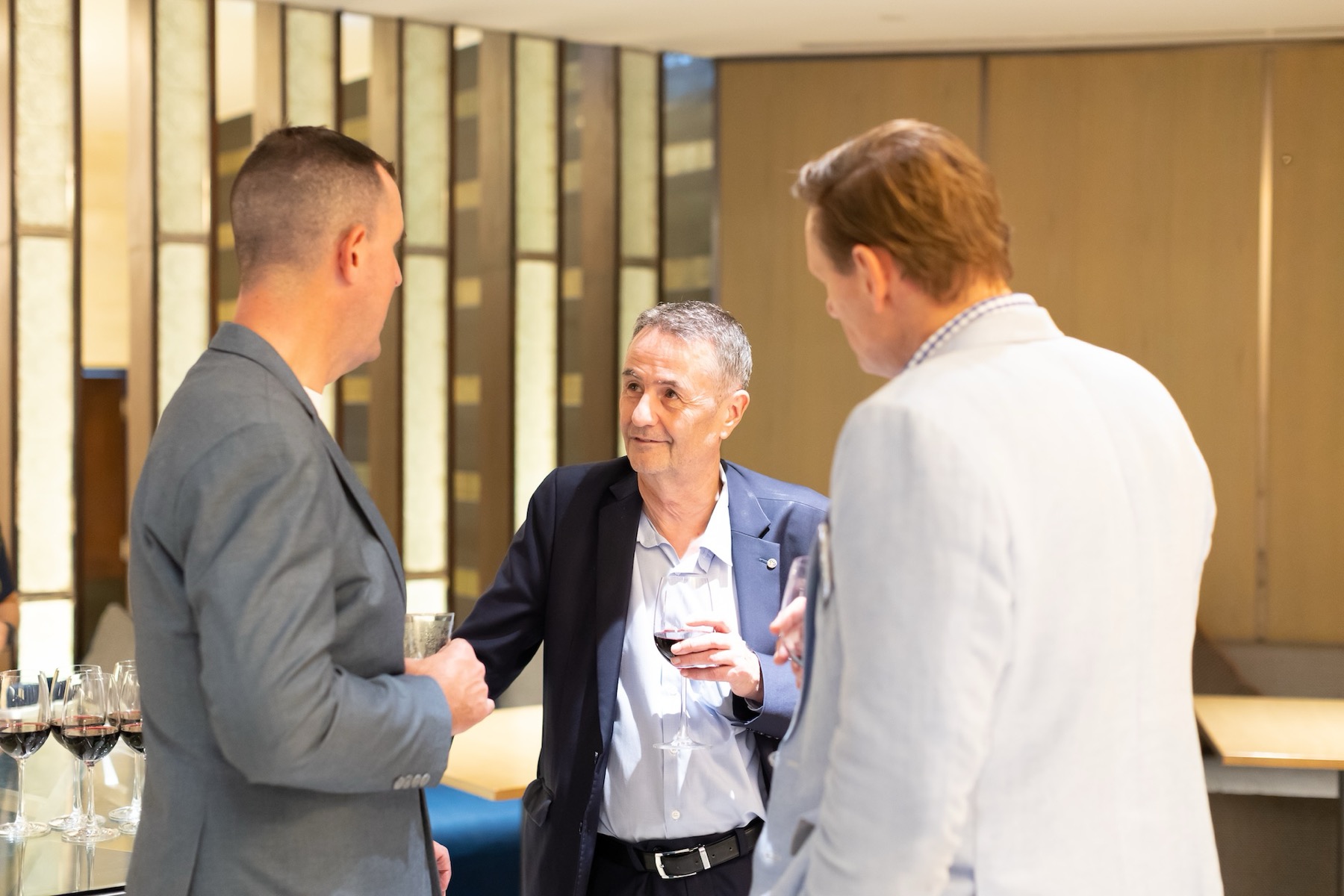 Three members talking over drinks at a Chamber event